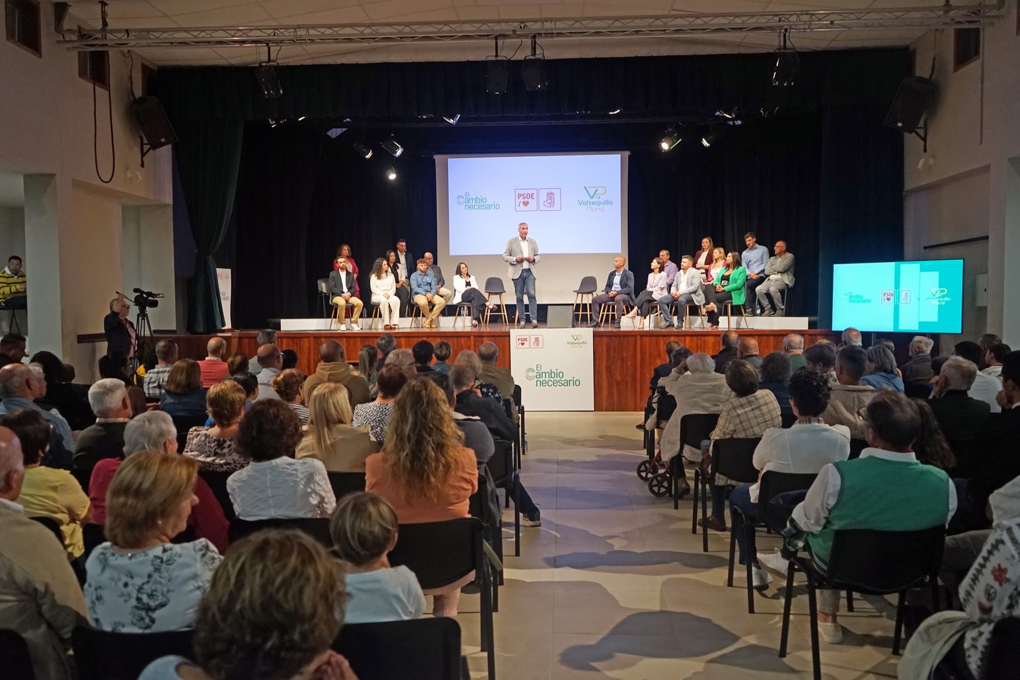 Vista general de un acto en un teatro, con la mesa presidencial en el escenario y la platea llena de público.